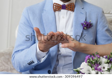 bride and groom holding hands, in the hands of the bride\'s wedding bouquet