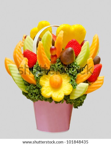 an assortment of fresh fruit in a fruit basket, resembling a flower bouquet isolated on grey background