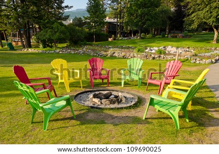 outdoor fireplace with three colorful chairs