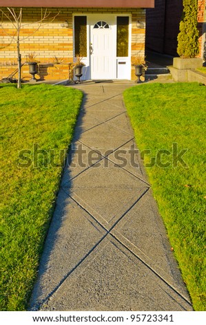 A nice entrance of a house with long path and outdoor landscape