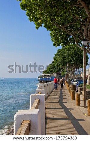 LAHAINA, HAWAII - CIRCA OCTOBER 2013: People walking along the boardwalk of Front Street in Lahaina Maui, Hawaii. Front street is a very popular tourist destination in Lahaina.