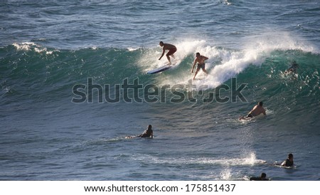HOOKIPA, HAWAII - CIRCA OCTOBER 2013: Young people surfing Hookipa, Maui. Hookipa is a beach on the north shore of Maui, Hawaii, USA, perhaps the most renowned windsurfing site in the world
