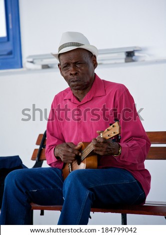 PANAMA CITY, PANAMA - JANUARY 18, 2014: An old musician playing for money in an  open air market in Casco Viejo in Panama City Panama. Casco Viejo was designated a World Heritage Site in 1997.