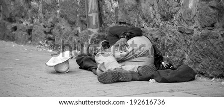 BOGOTA, COLOMBIA - MAY 06, 2014: An unidentified homeless man sleeping in the streets of Bogota Colombia. The World Bank estimates that one in three people live below the poverty line in Colombia.