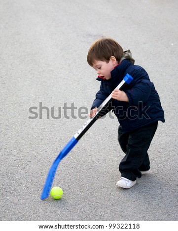 Toddler playing street hockey