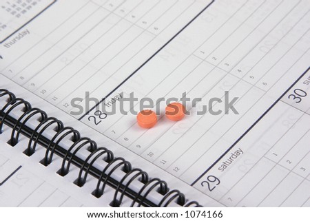 Date book with two orange pills near date/time.
