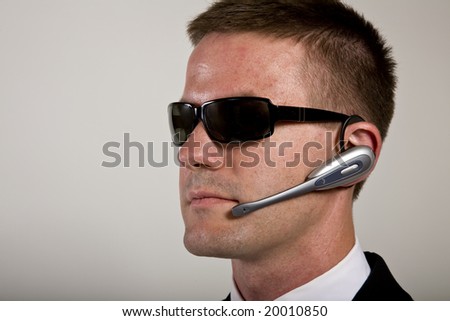 Young man suggesting a secret service agent or secret policeman listening on a headset.