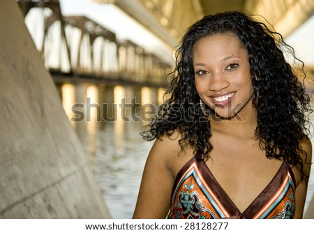 African-american Fashion model shot against  a body of water.