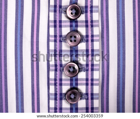 Close-up of buttons on a striped purple shirt
