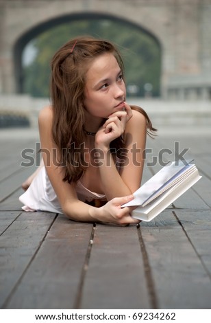 The young girl reads the book.
