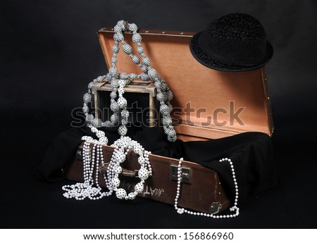 Old vintage luggage bag decorated with beads on the black background