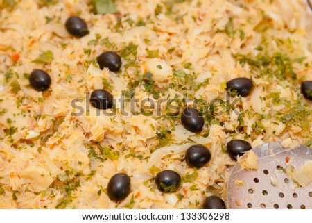 Portuguese dish contains dried Cod fish which has been hydrated and desalted, peeled boiled sliced potatoes, glazed yellow sliced onion, whole pitted black olives, and chopped parsley