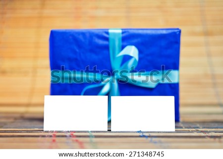 Two horizontal business card invitation mockup over blue gift. Can be used for the presentation of the brand, company or person. Business card are clipped.