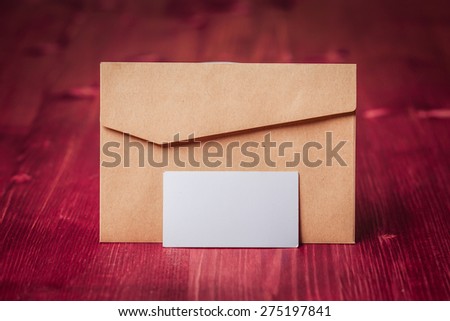 Craft envelope with business card template on old wood background.