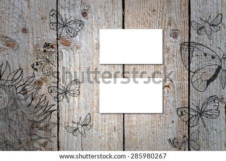 Horizontal business card mockup over natural wood deck table background. Card is 50x90mm. Wood deck have doodle pictures with sunflowers and butterflies.