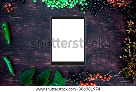 Tablet (4:3) mockup on frame frame with berries, leaves, red currant, green peas, barberry and apple on vintage wood table
