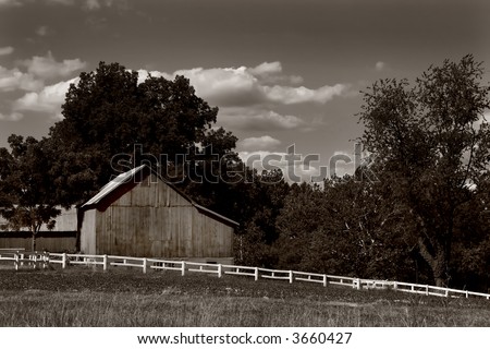 Sepia toned black and white photo of a barn and white fence in Harford County, Maryland