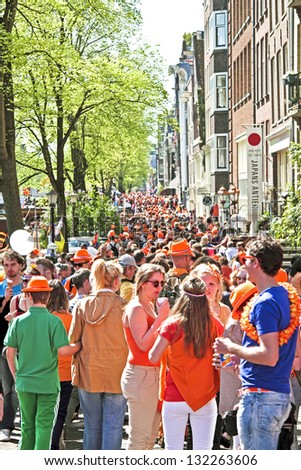 AMSTERDAM - APRIL 30: Big crowds in orange from people partying in the streets during the celebration of queensday on April 30, 2012 in Amsterdam, The Netherlands
