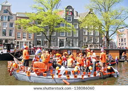 AMSTERDAM, NETHERLANDS - APRIL 30: People in orange cruising through the canals from Amsterdam during the coronation of the new king Willem Alexander from the Netherlands on 30 april 2013