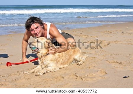 Young guy playing with his dog at the beach