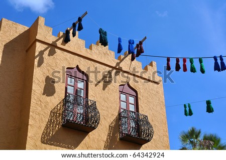 A traditional north African house with windows, balconies and hanging decorations on a bright sunny day