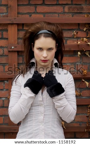 Beautiful girl standing in front of a brick wall background, romantic/gothic look