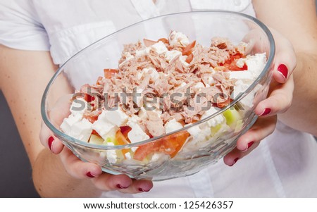 An image of girl holding tuna salad in salad bowl