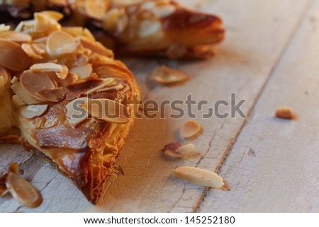 Fresh berry and almond pinwheel pastry, sprinkled with icing sugar on a brown wooden serving board with copy space - Shallow Depth of Field (DOF)