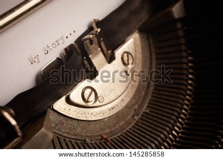 A Closeup image of the typebars and ribbon of an old style typewriter and paper with the text: My Story... (Shallow Depth of Field)