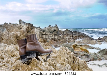 Brown leather boots on the rocks at the sea