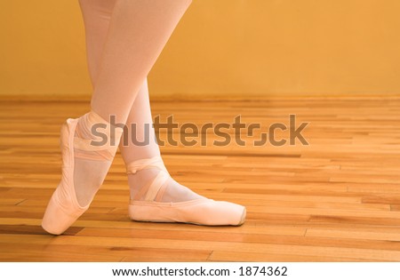 Woman pointing with ballet shoes.