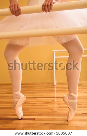 Ballerina standing at a ballet bar.