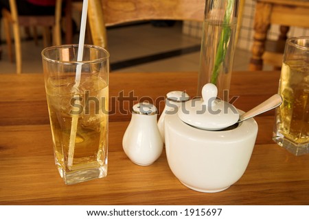 Drink on the table with salt, pepper and sugar bowl