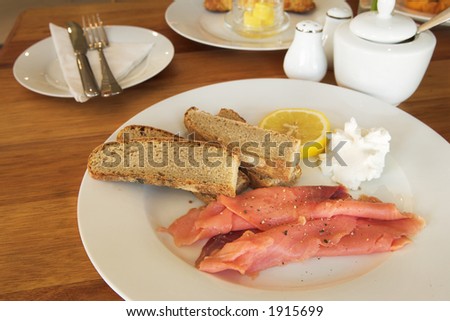 Whole wheat bread with salmon, lemon and cream on a plate