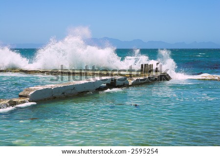 Wave breaking against the harbor wall, Kalk Bay, Western Cape, South Africa