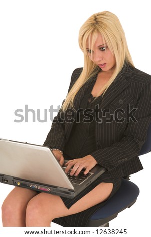 Sexy young adult Caucasian businesswoman in black pinstripe pencil skirt and suit jacket on a white background, sitting on an office chair with a notebook computer