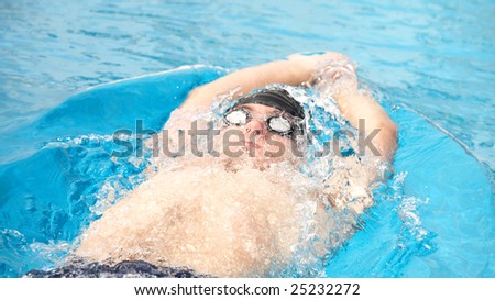 Healthy young adult male aquatic athlete. Professional swimmer in blue water