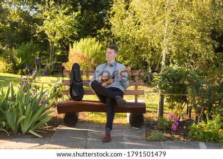 Similar – Image, Stock Photo Cheerful man playing ukulele guitar