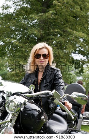 Woman in black leather jacket on a motorcycle