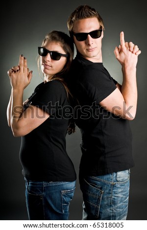 wild couple with sunglasses and finger guns