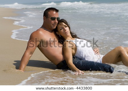 Couple enjoying the beach, sun and sand.  Blue sky in the background