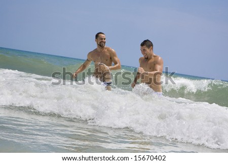 Two men running in the ocean