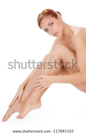 portrait of a beautiful young woman touching her legs isolated over white background