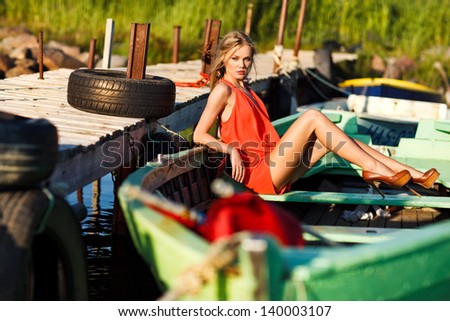 picture of beautiful girl in red dress sitting in a boat