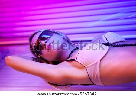 glamour young woman tanning in solarium