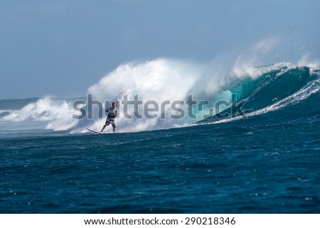 Kite surfer rides among the huge tubes and waves of the Indian Ocean on the island of Mauritius
