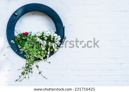 Flowers arrangement in old porthole/Porthole with fresh flowers/Flowers growing in porthole