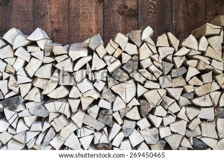Stacked fire wood and barn wall /Oak wood stacked for fire on barn wall/Oak tree wood stacked for fire in the barn