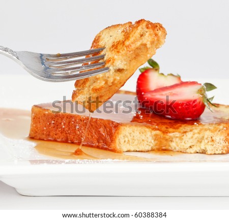French toast with drip of syrup and strawberries isolated on white background