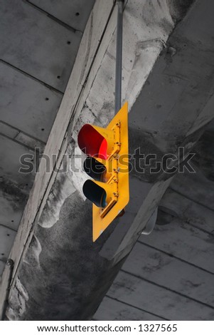 A yellow traffic light with a concrete background.